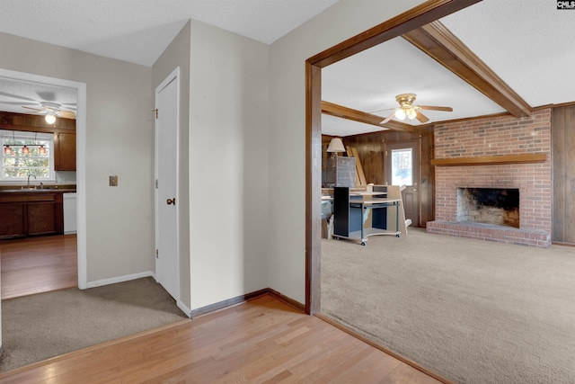 interior space with light colored carpet, beam ceiling, sink, and a textured ceiling