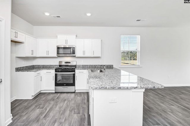 kitchen featuring white cabinetry, stainless steel appliances, sink, and light stone counters