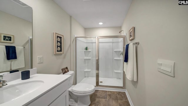 bathroom featuring an enclosed shower, vanity, and toilet