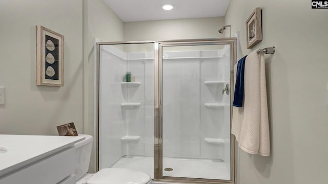 bathroom with walk in shower, vanity, and toilet