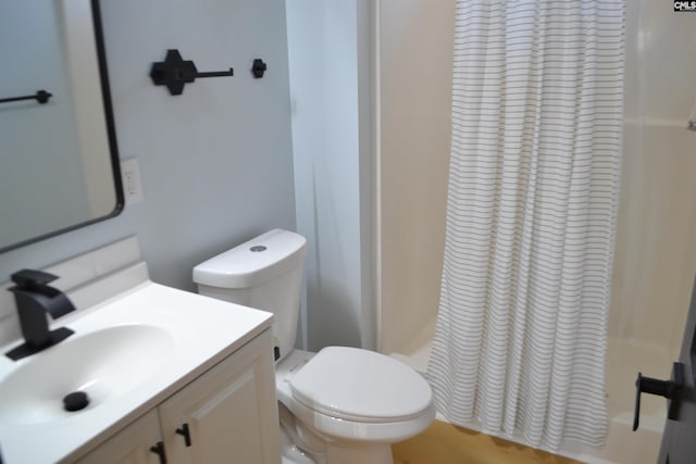 bathroom with toilet, curtained shower, and vanity