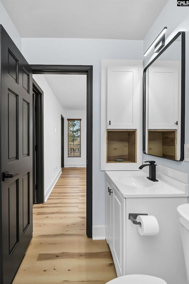 bathroom with hardwood / wood-style flooring, vanity, and toilet