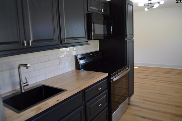 kitchen with light hardwood / wood-style flooring, tasteful backsplash, butcher block counters, stainless steel range with electric cooktop, and sink