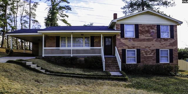 tri-level home featuring a front yard and a porch