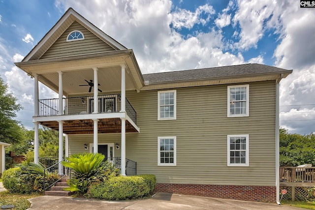 back of property featuring ceiling fan, a balcony, and covered porch