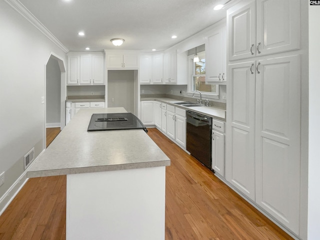 kitchen featuring a center island, white cabinetry, a sink, and black appliances