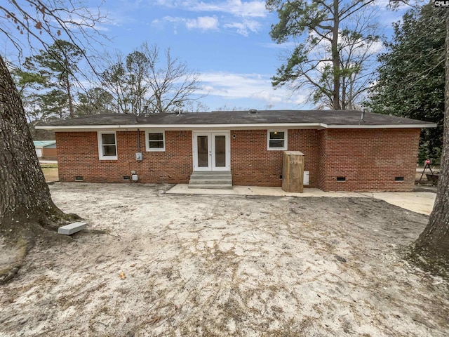 back of property with crawl space, brick siding, a patio, and french doors