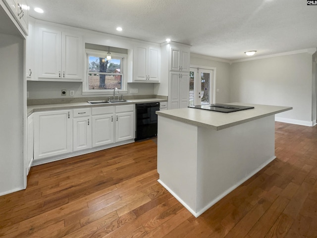 kitchen featuring black appliances, light countertops, a sink, and white cabinetry