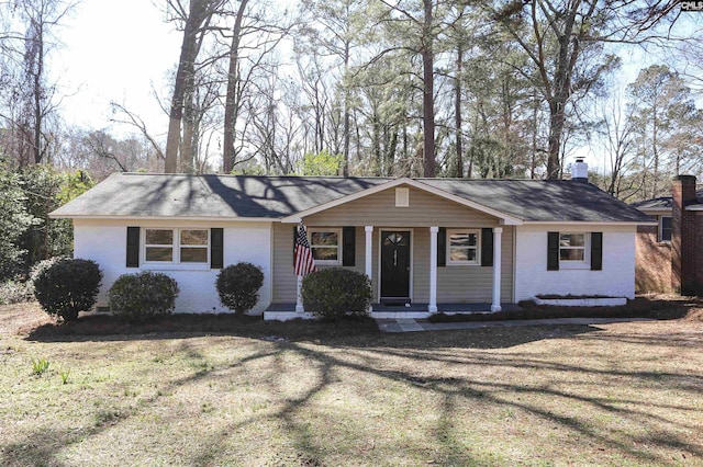 ranch-style home with covered porch and a front lawn