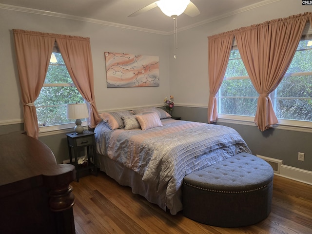 bedroom with baseboards, wood finished floors, a ceiling fan, and crown molding