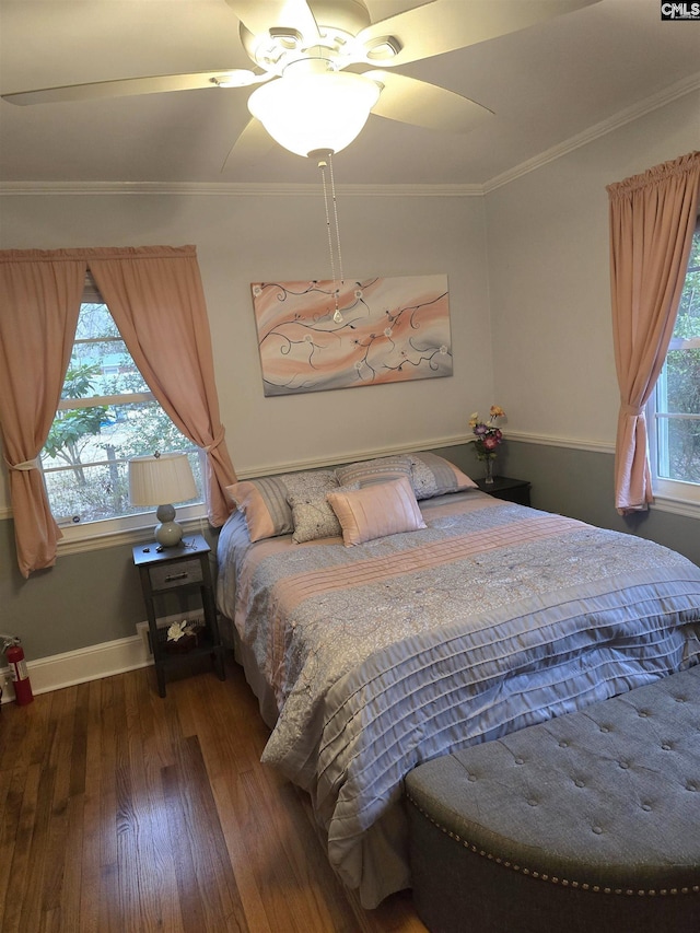 bedroom featuring multiple windows, baseboards, crown molding, and wood finished floors