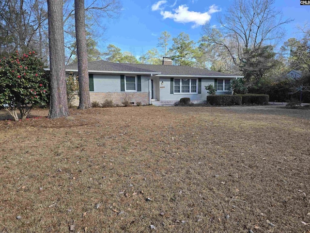 single story home with a front lawn, a chimney, and brick siding