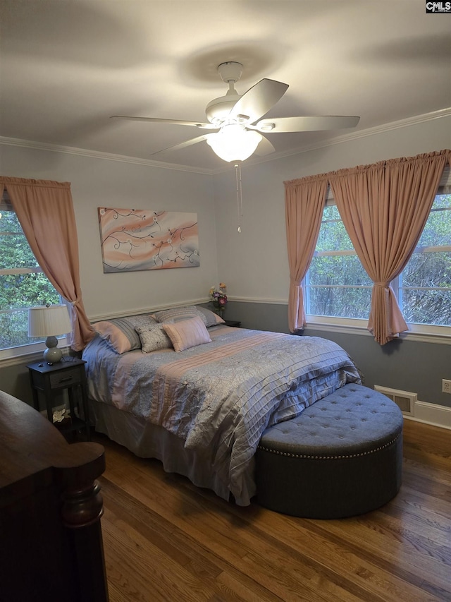 bedroom with ornamental molding, visible vents, multiple windows, and wood finished floors