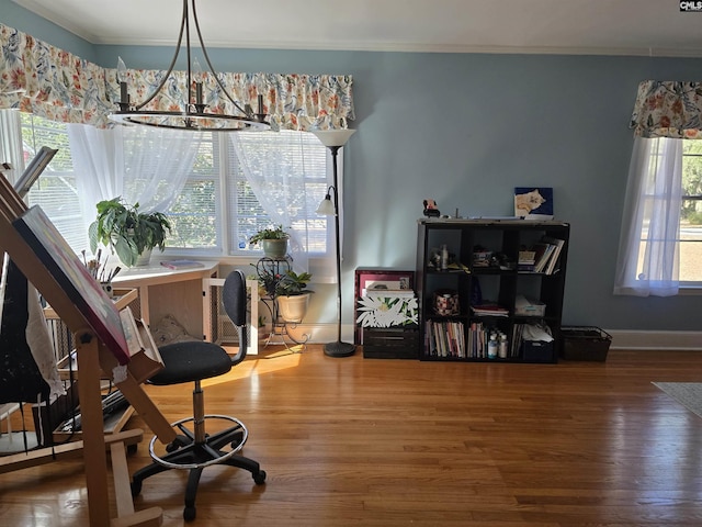 living area with ornamental molding, wood finished floors, and baseboards