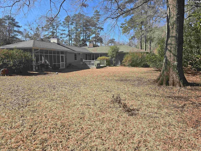 back of property featuring a sunroom and a chimney