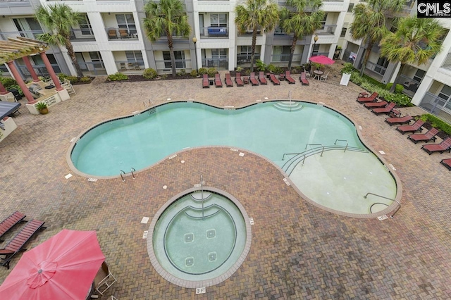 view of swimming pool with a community hot tub