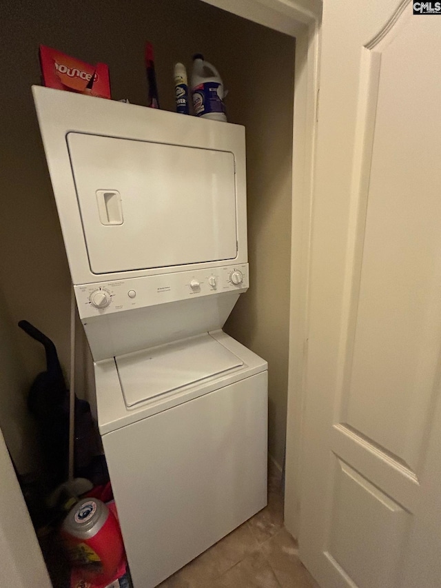 clothes washing area with stacked washer and dryer and light tile patterned floors