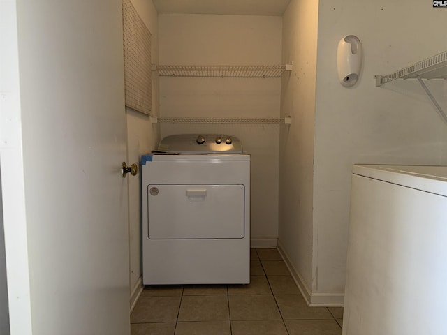 washroom featuring washer and clothes dryer and light tile patterned floors