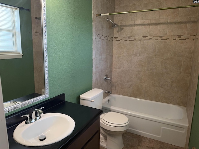 full bathroom with tiled shower / bath, vanity, toilet, and tile patterned floors