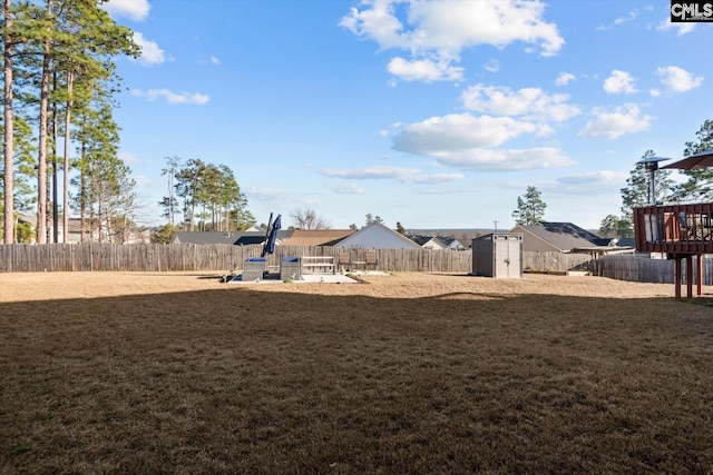 view of yard featuring a deck and a storage unit