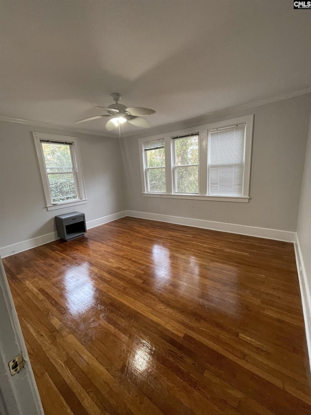 unfurnished living room featuring ornamental molding, dark hardwood / wood-style floors, heating unit, and ceiling fan