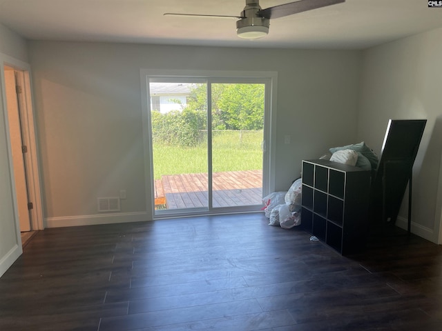 empty room with ceiling fan and dark hardwood / wood-style flooring