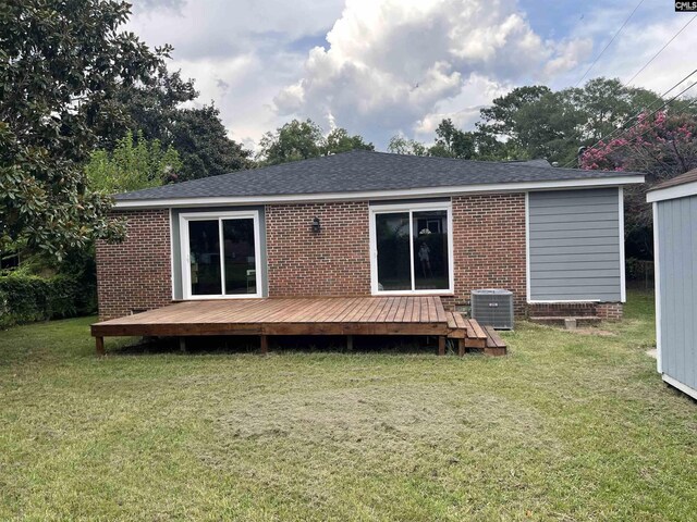 rear view of property featuring central AC, a deck, and a lawn