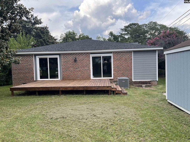 rear view of property featuring a yard, cooling unit, and a deck