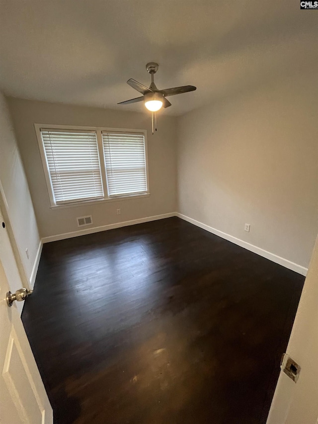 unfurnished room with dark hardwood / wood-style floors and ceiling fan