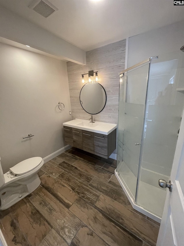 bathroom featuring vanity, wood walls, toilet, and walk in shower