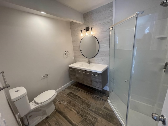 bathroom with vanity, wooden walls, a shower with door, and toilet