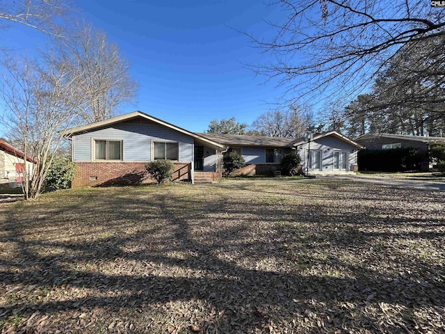 single story home featuring a front yard, crawl space, and brick siding