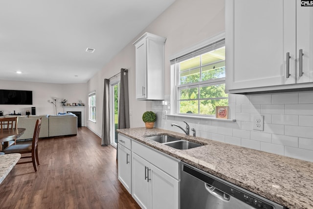 kitchen featuring dishwasher, light stone countertops, white cabinets, backsplash, and sink