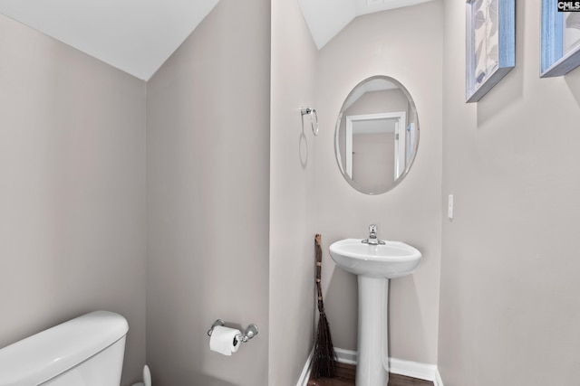 bathroom with lofted ceiling, sink, and toilet