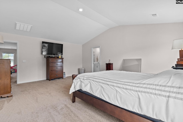 carpeted bedroom featuring lofted ceiling and ensuite bath