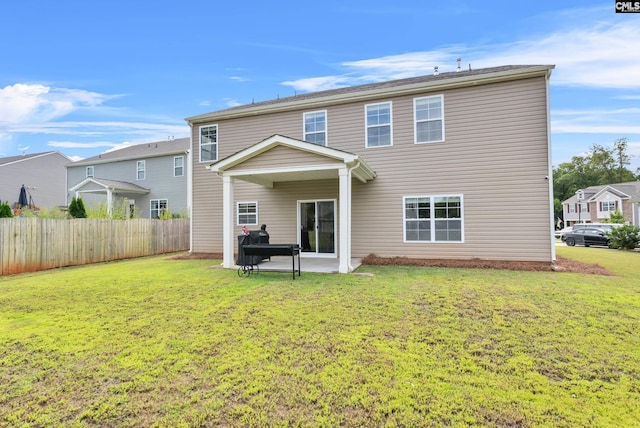 back of property with a patio area and a lawn