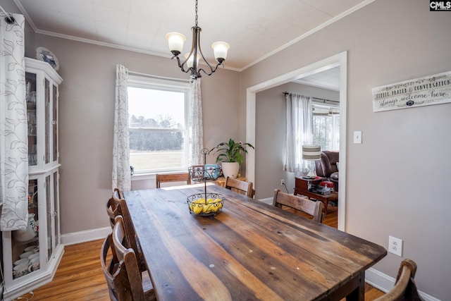 dining area with crown molding, a notable chandelier, and wood-type flooring