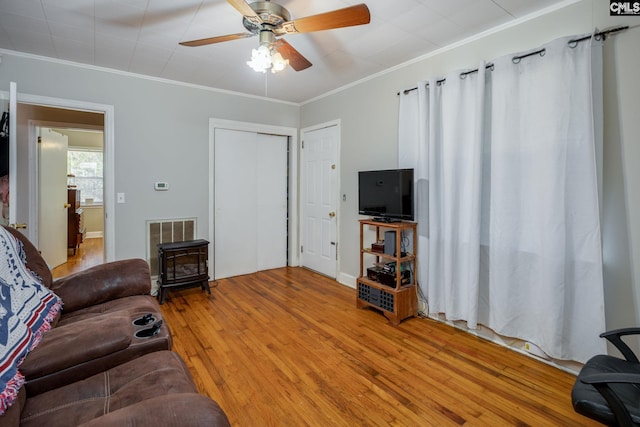 living room with hardwood / wood-style floors, ceiling fan, and crown molding