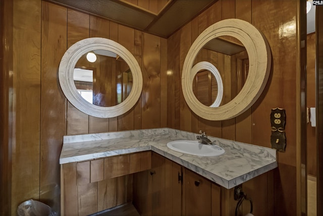 bathroom with vanity and wood walls