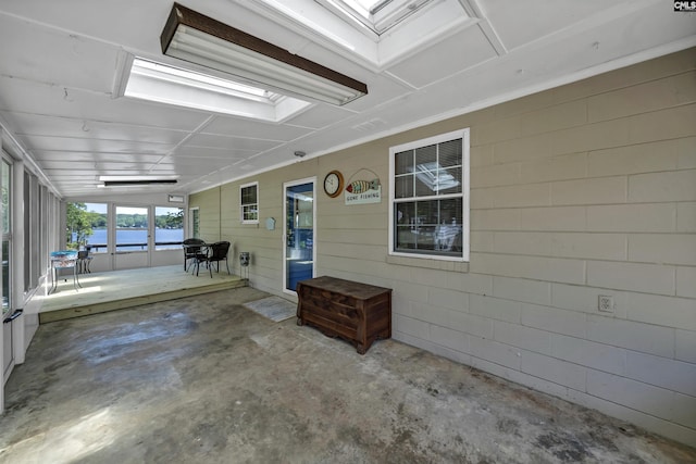 unfurnished sunroom with a skylight and a water view