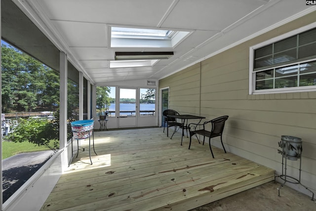 sunroom / solarium with a water view and lofted ceiling with skylight