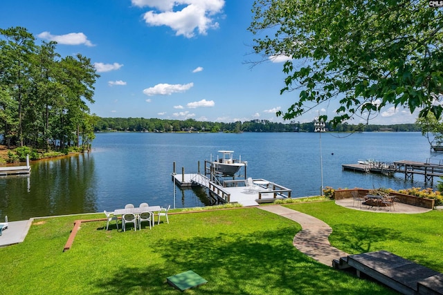 dock area featuring a fire pit, a water view, and a lawn