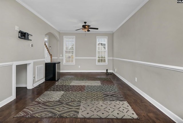 unfurnished living room with crown molding, dark wood-type flooring, and ceiling fan