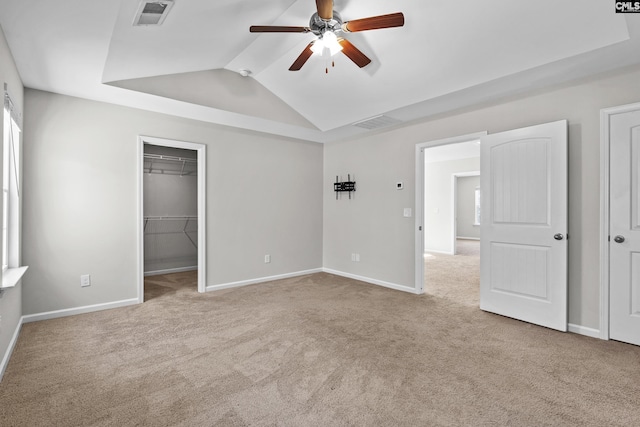 unfurnished bedroom featuring light carpet, lofted ceiling, ceiling fan, and a closet