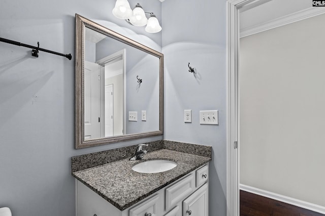 bathroom with hardwood / wood-style flooring, ornamental molding, and vanity