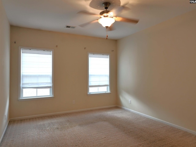 carpeted spare room with plenty of natural light and ceiling fan