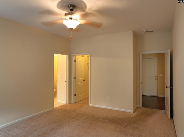 unfurnished bedroom featuring light carpet, ceiling fan, and connected bathroom