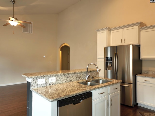 kitchen with sink, white cabinets, stainless steel appliances, and an island with sink