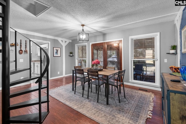 dining area featuring an inviting chandelier, dark hardwood / wood-style flooring, and a textured ceiling