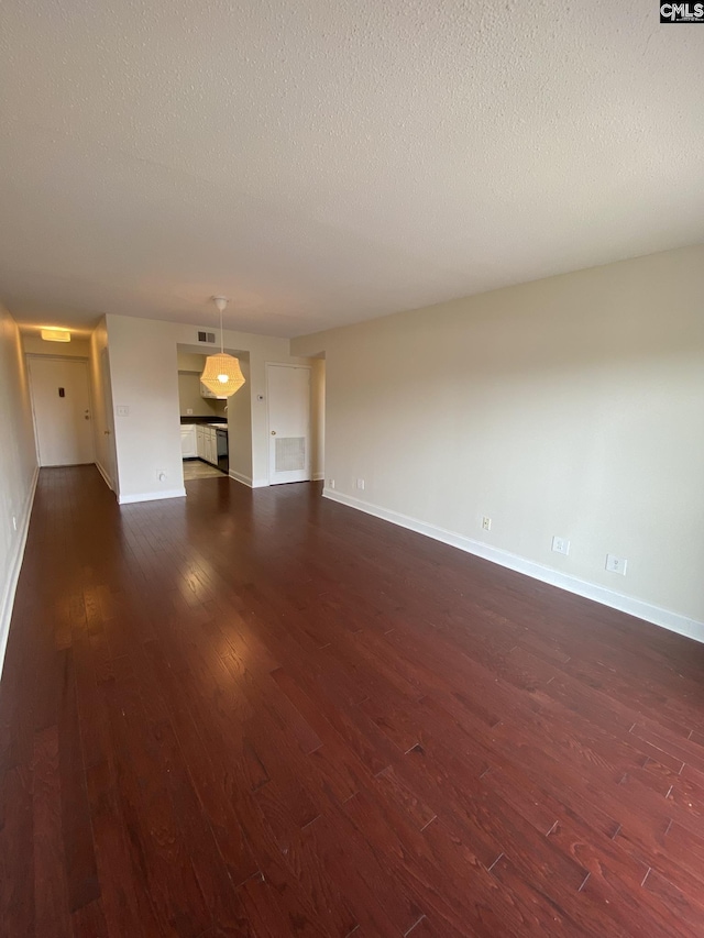 unfurnished living room featuring a textured ceiling and dark wood-type flooring